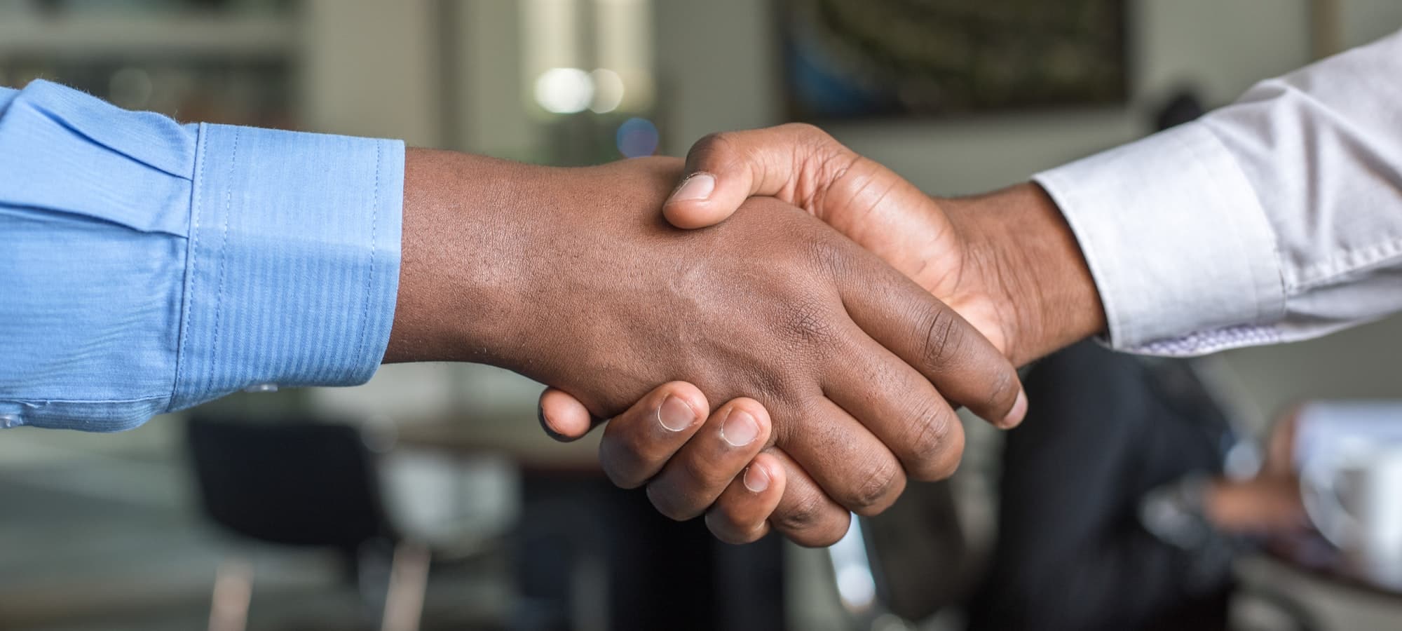 Two people shaking hands at the close of a meeting.