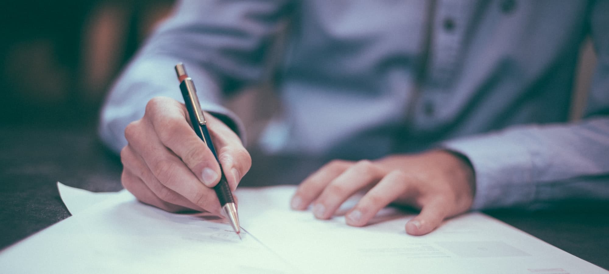 A person marking up a printed document with a pen.