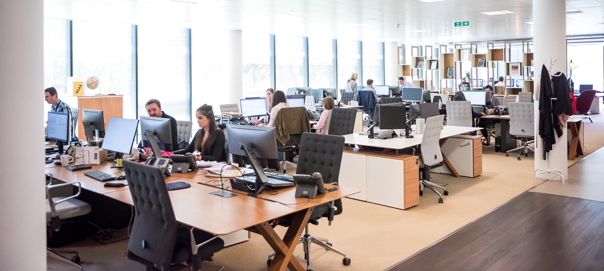 A busy open plan office, with desk telephones beside every workstation.